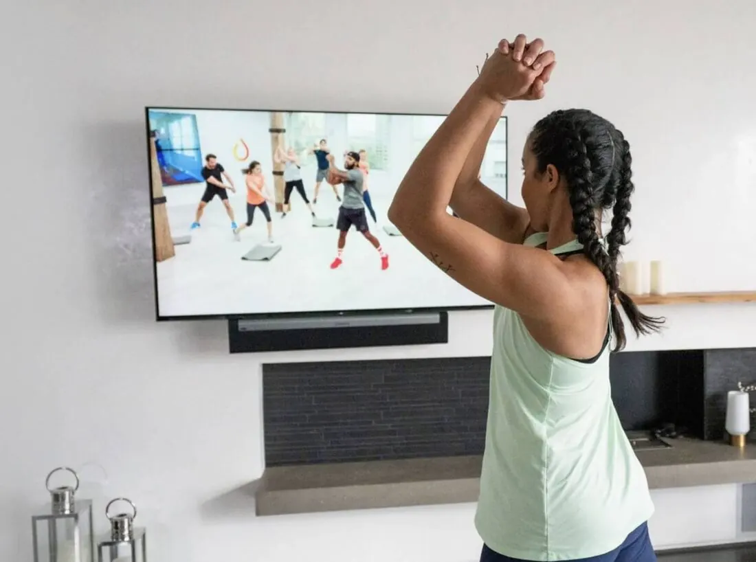 A member following a Daily Burn class on her living-room TV